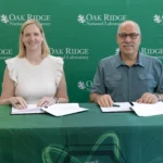 Krista Wiegand and Moe Khaleel sign MOU between Baker School and ORNL.