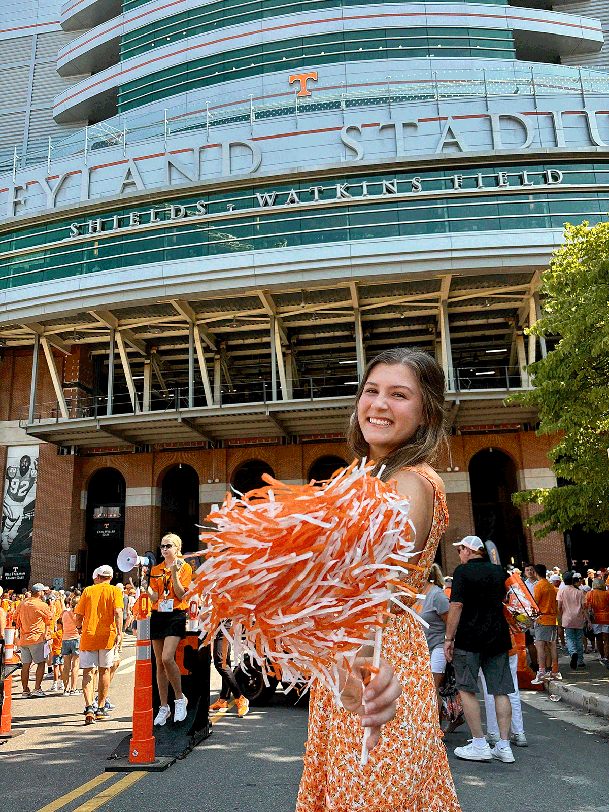 Photo of Addie Davis with pom poms in front of Neyland Stadium